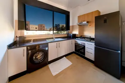 a kitchen with a washer and dryer in it at Prestigia Exceptional apartment with pool view in Marrakech