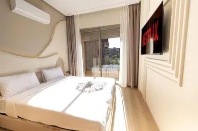 a bedroom with a white bed and a window at Prestigia Exceptional apartment with pool view in Marrakech