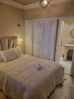 a bedroom with a large white bed and a table at Palais Majorelle - Entire Chic 3Bedrms 3Bathrms Duplex in Marrakech with Majorelle View, 2 Lounges, Prime Central Location in Marrakech