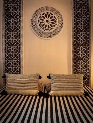 a room with two pillows and a wall with a painting at Loft house Marrakech in Marrakech