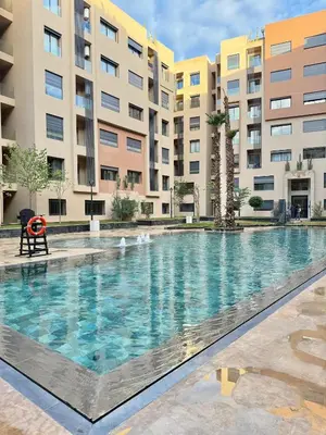 a swimming pool in front of some apartment buildings at Appartement vue piscine & fitness à Guéliz in Marrakech