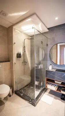 a bathroom with a glass shower and a toilet at Appartement vue piscine & fitness à Guéliz in Marrakech