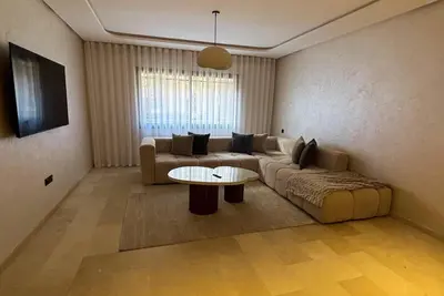 a living room with a couch and a table at Appartement vue piscine & fitness à Guéliz in Marrakech
