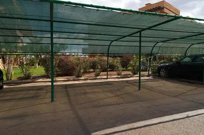 a green parking lot with a car parked underneath at Stylish Apartment with Pool in Marrakech in Marrakech