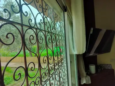 a glass door with a view of a green yard at Berber House Authentic Moroccan Farm Stay in El Rhechat
