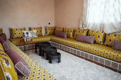 a living room with a long couch with yellow and purple pillows at Chamali House Peaceful Nature Farm Stay Ferme Zarraba in El Rhechat