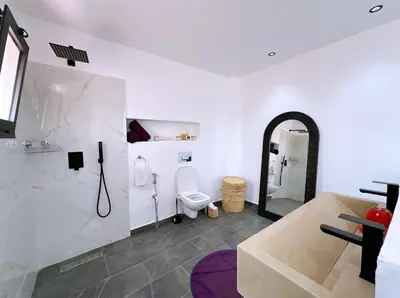 a white bathroom with a toilet and a shower at Villa nakhil in Marrakech