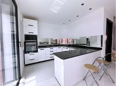 a kitchen with white cabinets and a black counter top at Villa nakhil in Marrakech