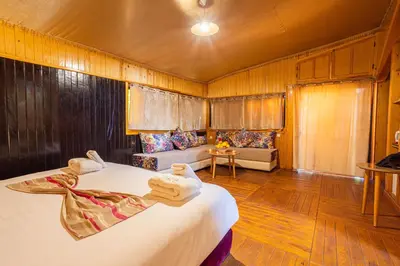 a bedroom with two beds and a couch in a room at Ferme dhôte Sidi Safou Cabane en bois Marrakech in Marrakech