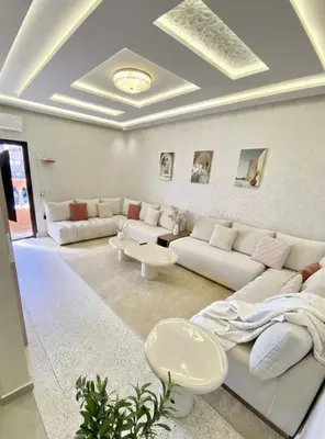 a white living room with couches and a table at Charmant cocon moderne in Marrakech
