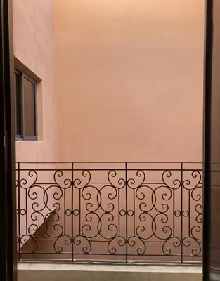 a balcony with a fence and a window at Charmant cocon moderne in Marrakech