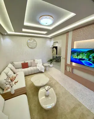 a living room with a white couch and a tv at Charmant cocon moderne in Marrakech