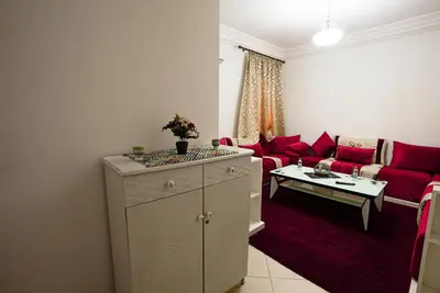 a living room with a red couch and a table at apartment in Hay mabrouka gueliz Marrakech in Marrakech