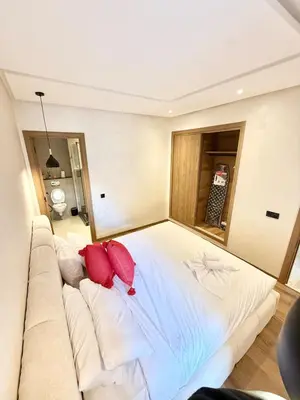 a bedroom with a large white bed with red pillows at Stylish and cozy accommodation for families in Marrakech