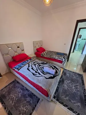 two beds sitting in a room with rugs at Appartement Lady Plaza 3 in Marrakech