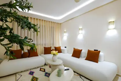 a living room with two white couches and a plant at Appartement vacances famille Marrakech in Marrakech