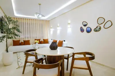a living room with a table and chairs and a couch at Appartement vacances famille Marrakech in Marrakech