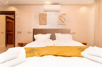 a bedroom with two beds with white sheets at Gueliz Stay in Marrakech