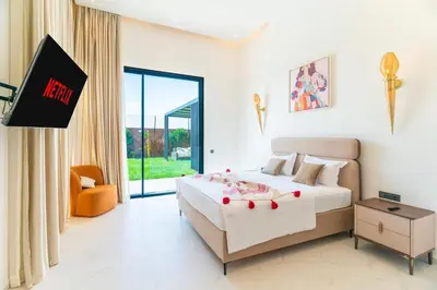 a bedroom with a bed and a tv in a room at Luxury Villa with Breakfast & Padel Access in Marrakech