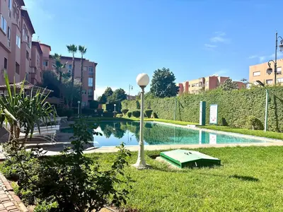 a swimming pool with a light pole in the grass at Cozy 2-bedroom apartment & pool & wifi in Marrakech