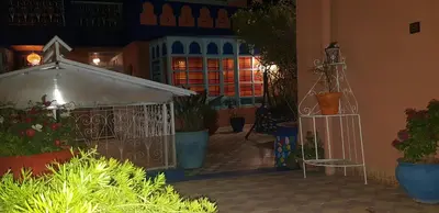 a garden with a white gate and some plants at Riad Konouz in Marrakech
