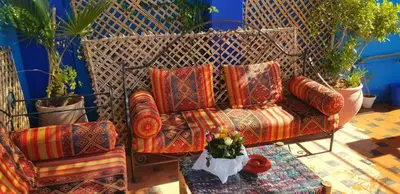 a couch with pillows and a vase of flowers at Riad Konouz in Marrakech
