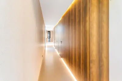 a hallway with a wooden wall with a light shining on it at VILLA Twenty six 1600m2 Marrakech LUXE & PROXIMITÉ in Marrakech