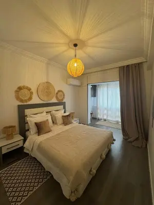 a bedroom with a large bed and a chandelier at Élégant et calme, à 2 minutes des meilleurs restaurants in Marrakech