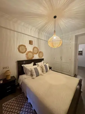 a bedroom with a large bed and a chandelier at Élégant et calme, à 2 minutes des meilleurs restaurants in Marrakech
