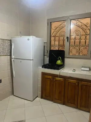 a kitchen with a white refrigerator and a window at modern apartment, 10 minutes from the airport in Oulad Akkou