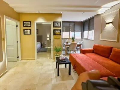 a living room with a couch and a table at Appartement neuf et chic Proche gare et CTM in Marrakech