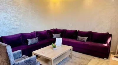 a purple couch in a living room with a table at Appartement cozy in Marrakech