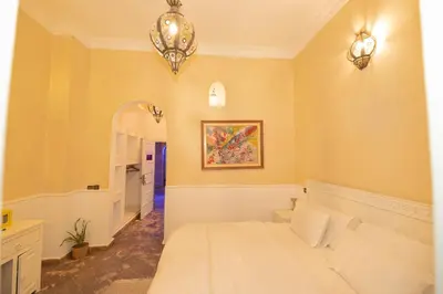 a bedroom with a white bed and a chandelier at Mumtaz Dar in Marrakech