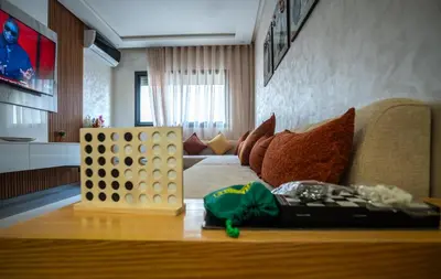 a living room with a table with a giant game at Oasis Urban & Balcon - 5 min de l'aeroport in Marrakech
