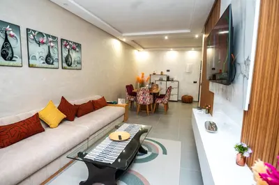 a living room with a couch and a tv and a table at Oasis Urban & Balcon - 5 min de l'aeroport in Marrakech