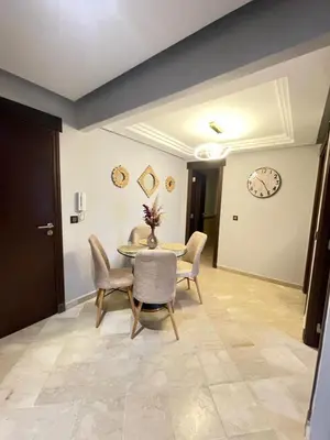 a dining room with a table and chairs and a clock at nice apartment, Luxury Wintering, Caprice Palace in Marrakech