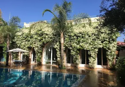 a house with a swimming pool and a palm tree at Private villa Marrakech in Marrakech