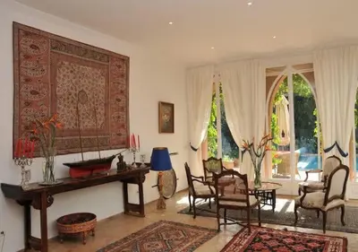 a living room with a table and chairs and a rug at Private villa Marrakech in Marrakech