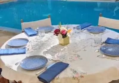a table with blue plates and a vase of flowers on it at Private villa Marrakech in Marrakech