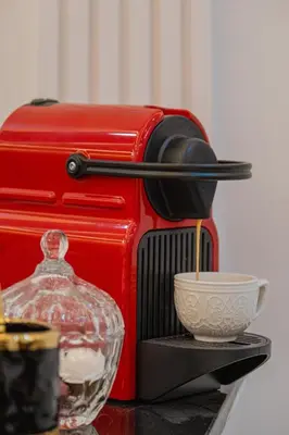 a red coffee maker and a bowl on a table at 2 King Suites 2 Living Rooms 3 min Gueliz Carre Eden in Marrakech