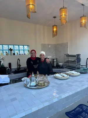 two people sitting at a table in a kitchen at Riad l'Oasis Bleue en privatisation 10 pers 3 jours mini in Marrakech