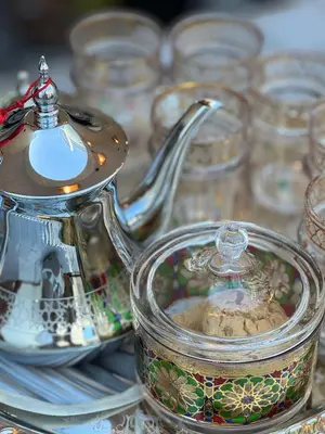 a glass teapot on a table with other glass dishes at Riad l'Oasis Bleue en privatisation 10 pers 3 jours mini in Marrakech