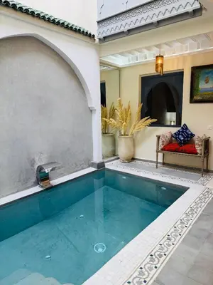 a pool in the middle of a living room with a couch at Riad l'Oasis Bleue en privatisation 10 pers 3 jours mini in Marrakech