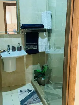 a bathroom with a sink and a toilet and a mirror at Elegant City Apartment in Marrakech