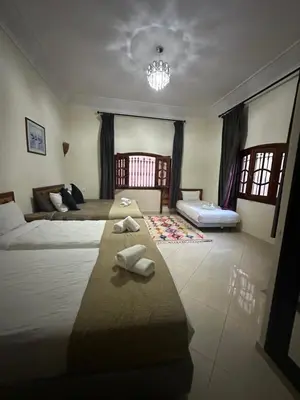 a large bedroom with two beds and a chandelier at Fekhara CC in Marrakech