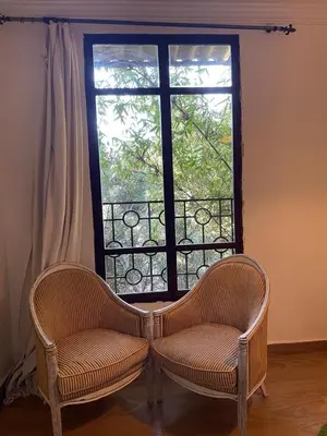 two chairs sitting in front of a window at Fekhara CC in Marrakech