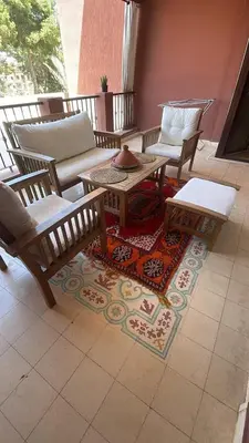 a patio with a table and chairs on a rug at Résidence Soltana in Marrakech