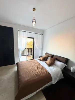 a bedroom with a large bed and a window at Modern apartment with Atlas view in Marrakech