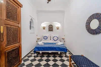 a bedroom with a bed and a checkerboard floor at Riad Lalla Rachida in Medina Heart Of Marrakech B&B in Marrakech