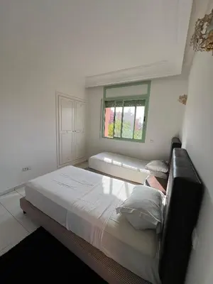 a bedroom with a large bed and a window at Marakech Giliz Atlas in Marrakech